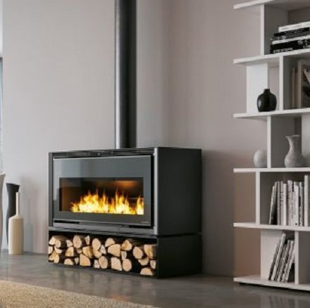 Stufa A Legna ad aria 12 Kw con focolare in Thermofix in Nera accesa in soggiorno, fiamma visibile attraverso il vetro