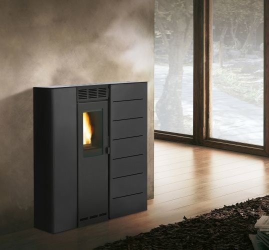 Stufa A Pellet salvaspazio Ecofire ad aria irraggiamento in accesa in soggiorno, fiamma visibile attraverso il vetro