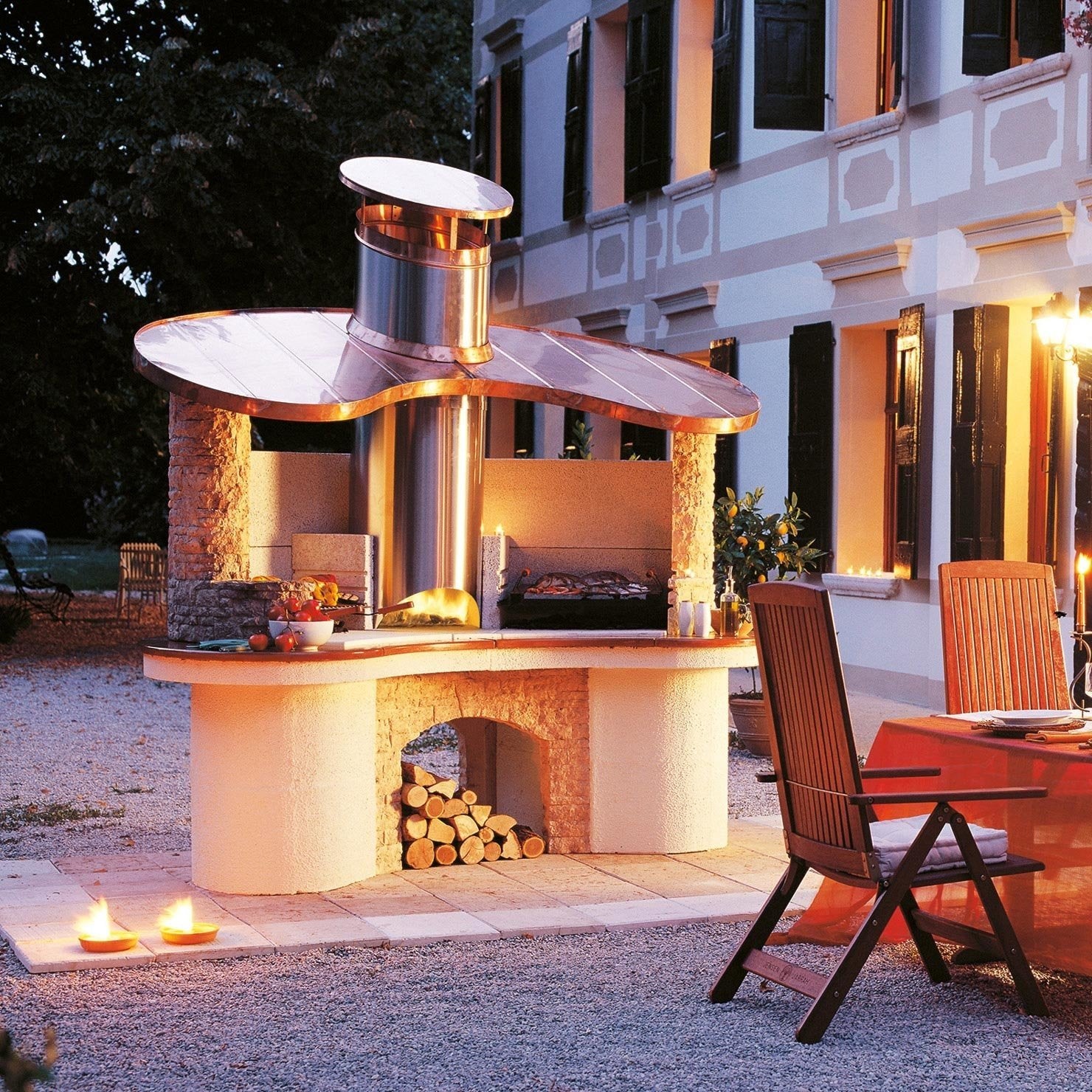 Palazzetti Sumatra barbecue con cappa in rame e piano in accesa in soggiorno, fiamma visibile attraverso il vetro