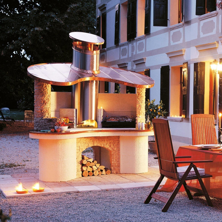 Palazzetti Sumatra barbecue con cappa in rame e piano in accesa in soggiorno, fiamma visibile attraverso il vetro