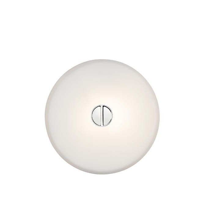 Flos Mini Button Lampada a Parete soffitto 14 cm in vetro in ottone accesa in ambiente, design e diffusione della luce