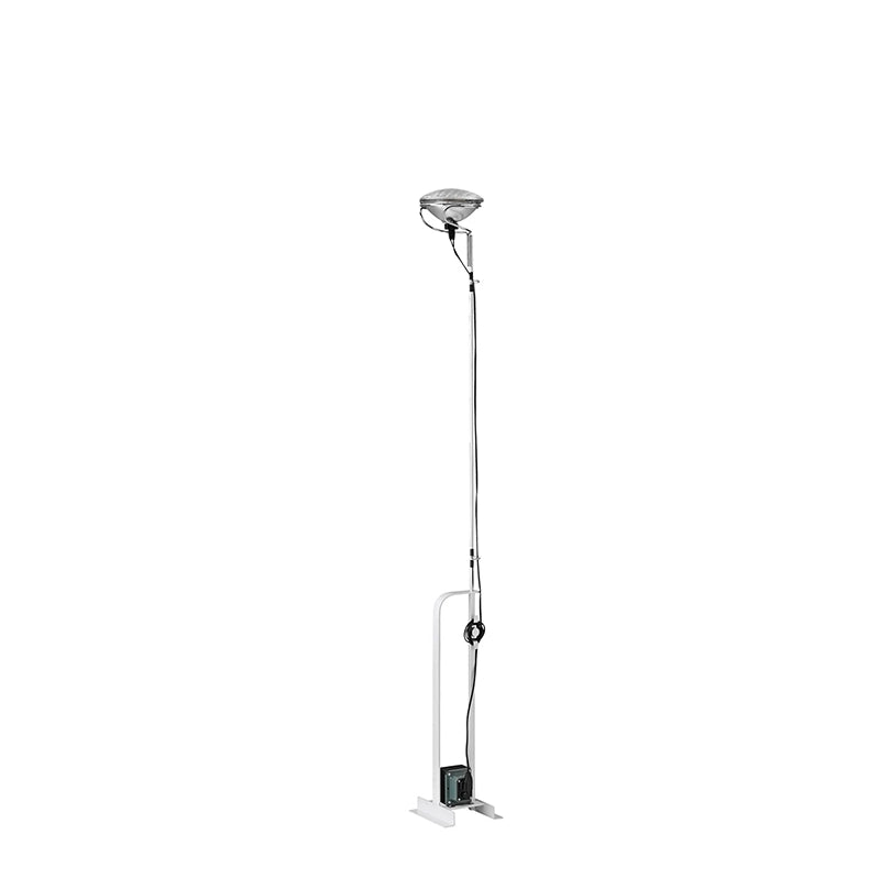 Flos Toio Led Lampada a Pavimento regolabile bianco in ottone accesa in ambiente, design e diffusione della luce