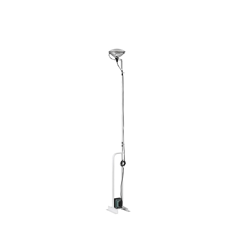 Flos Toio Led Lampada a Pavimento regolabile bianco in ottone accesa in ambiente, design e diffusione della luce