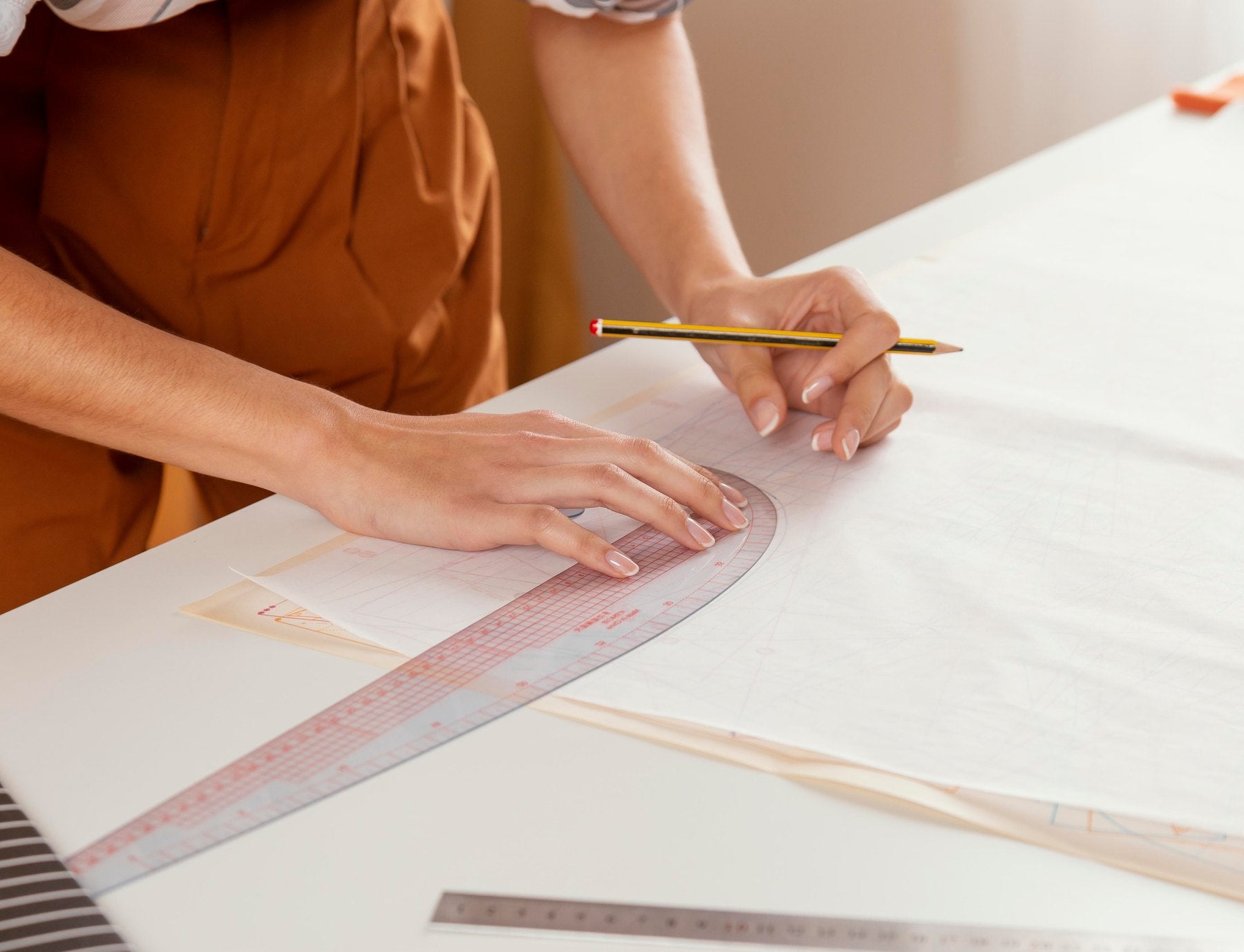 Persona che disegna un progetto con matita e righello
